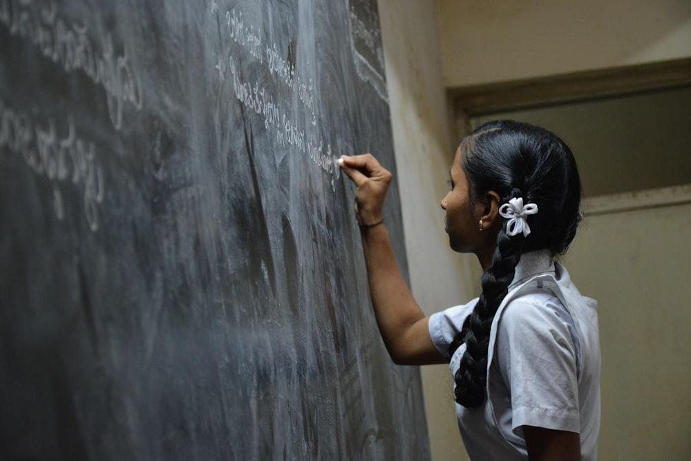 A schoolgirl writing on the blackboard